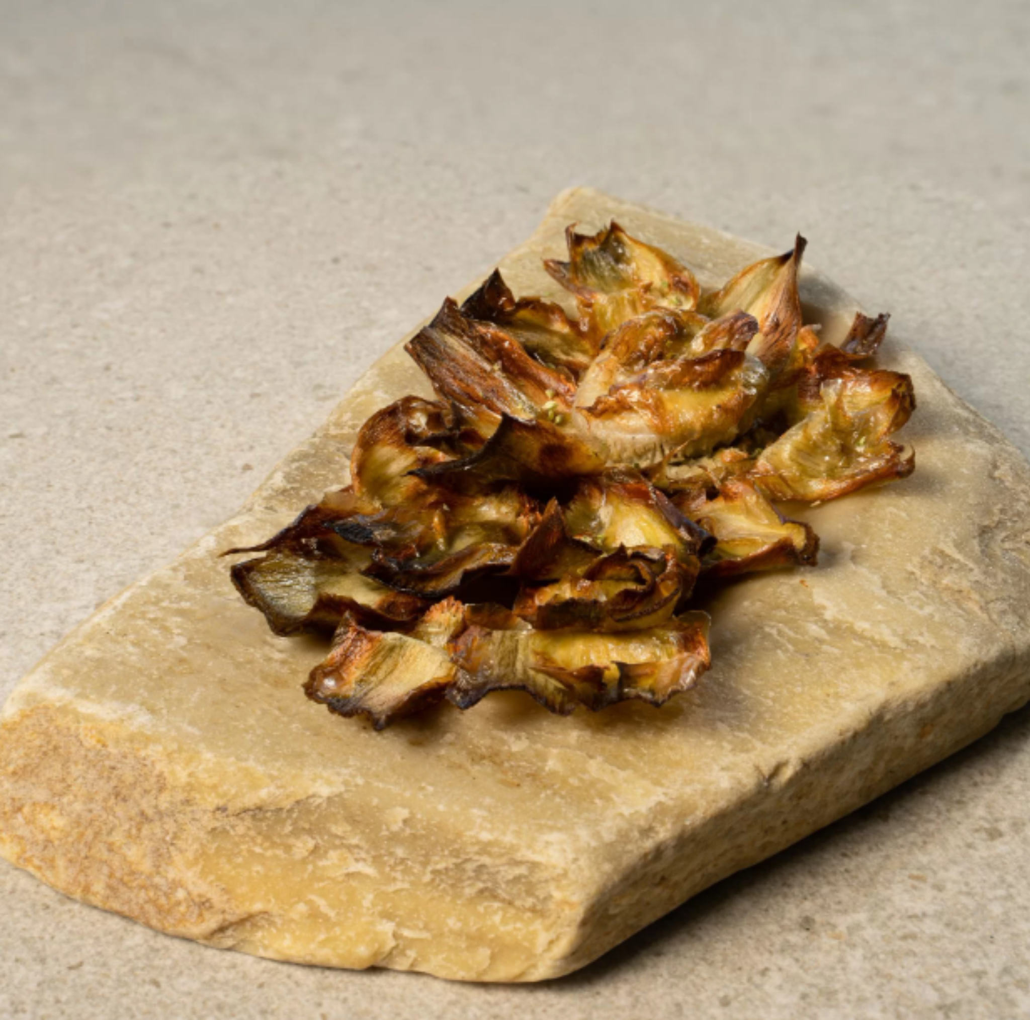 Baked artichokes from Caprichos del Paladar on a stone surface
