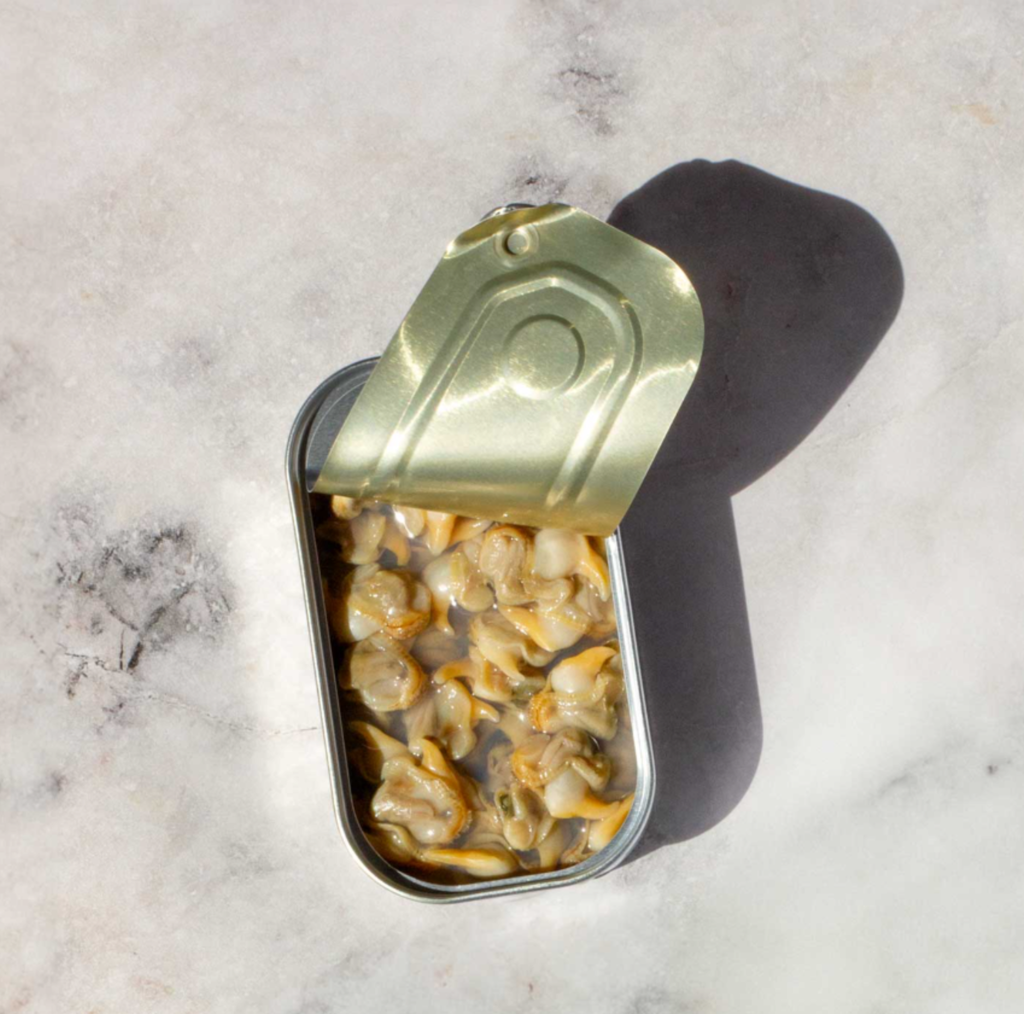 Metal tin with gold lid containing cockles