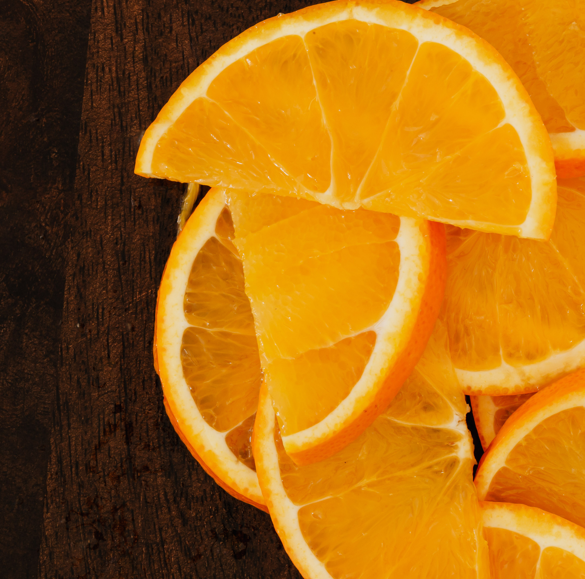 Sliced oranges on a dark wooden surface