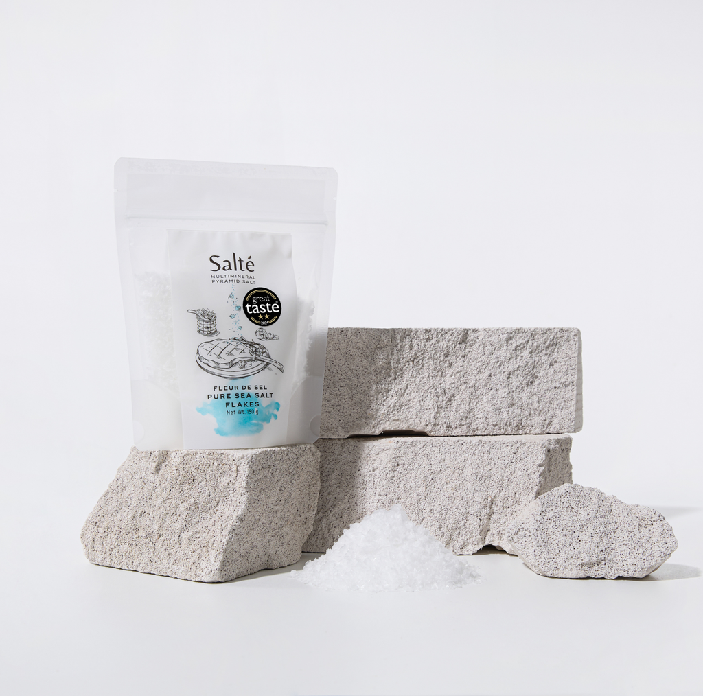 Blocks of sea salt and a packaging bag labeled 'Salté' on a white background
